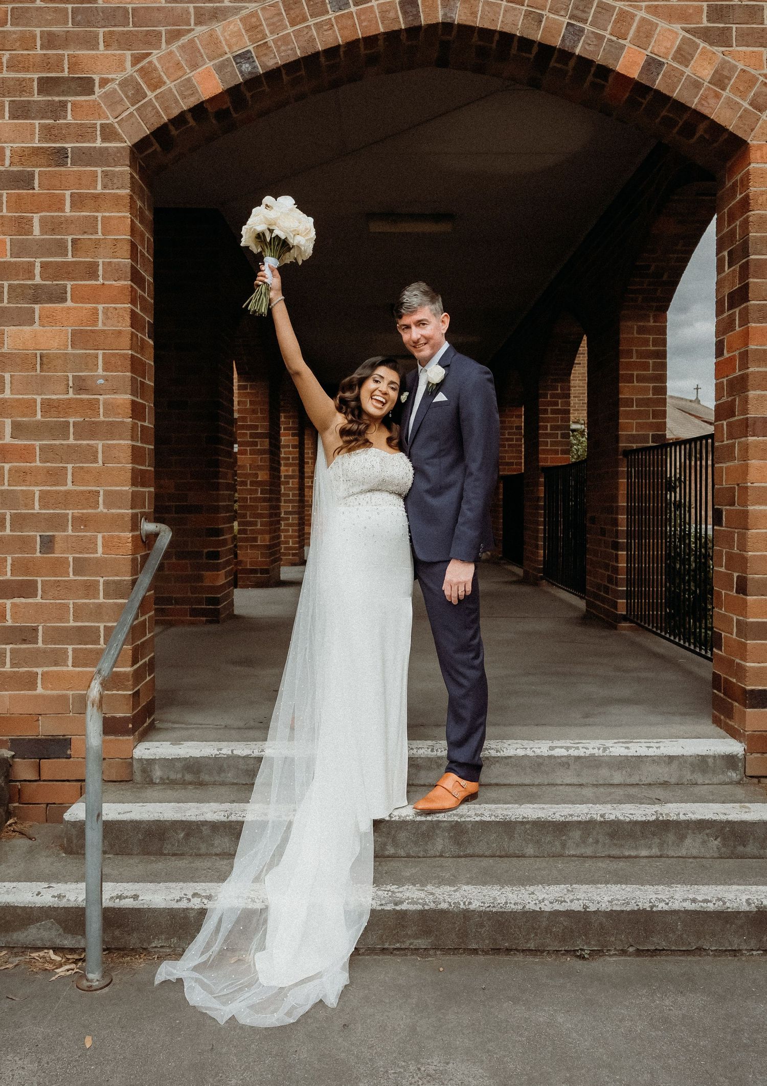 A wedding couple poses in front of a brick archway in a sequence of five progressive candid moments.