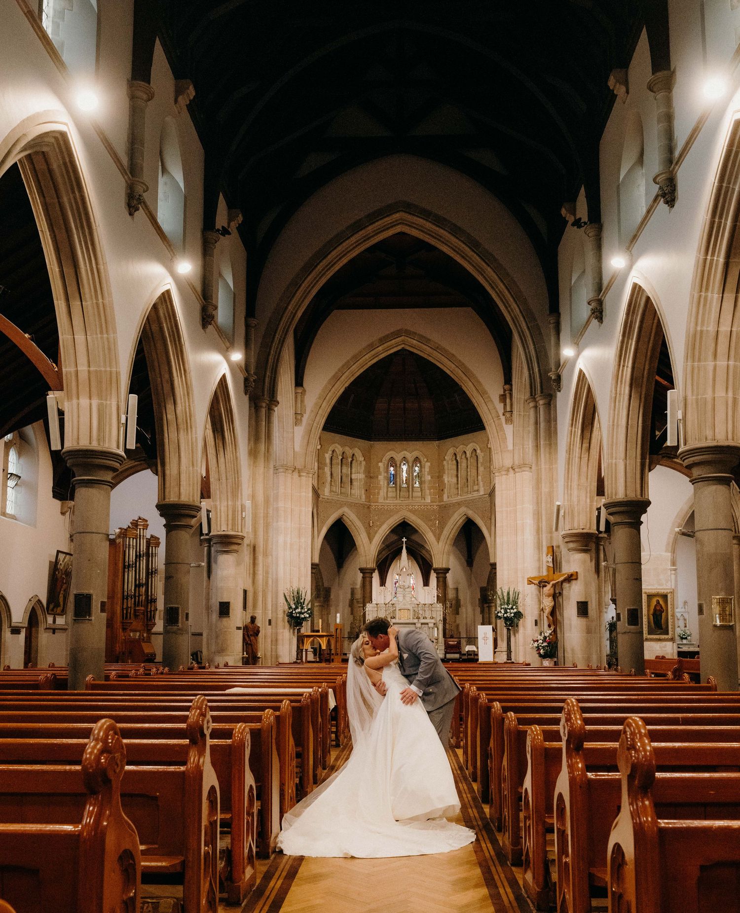 Interior view of a grand church sanctuary with gothic arches, wooden pews and dramatic lighting creating an ethereal atmosphere.