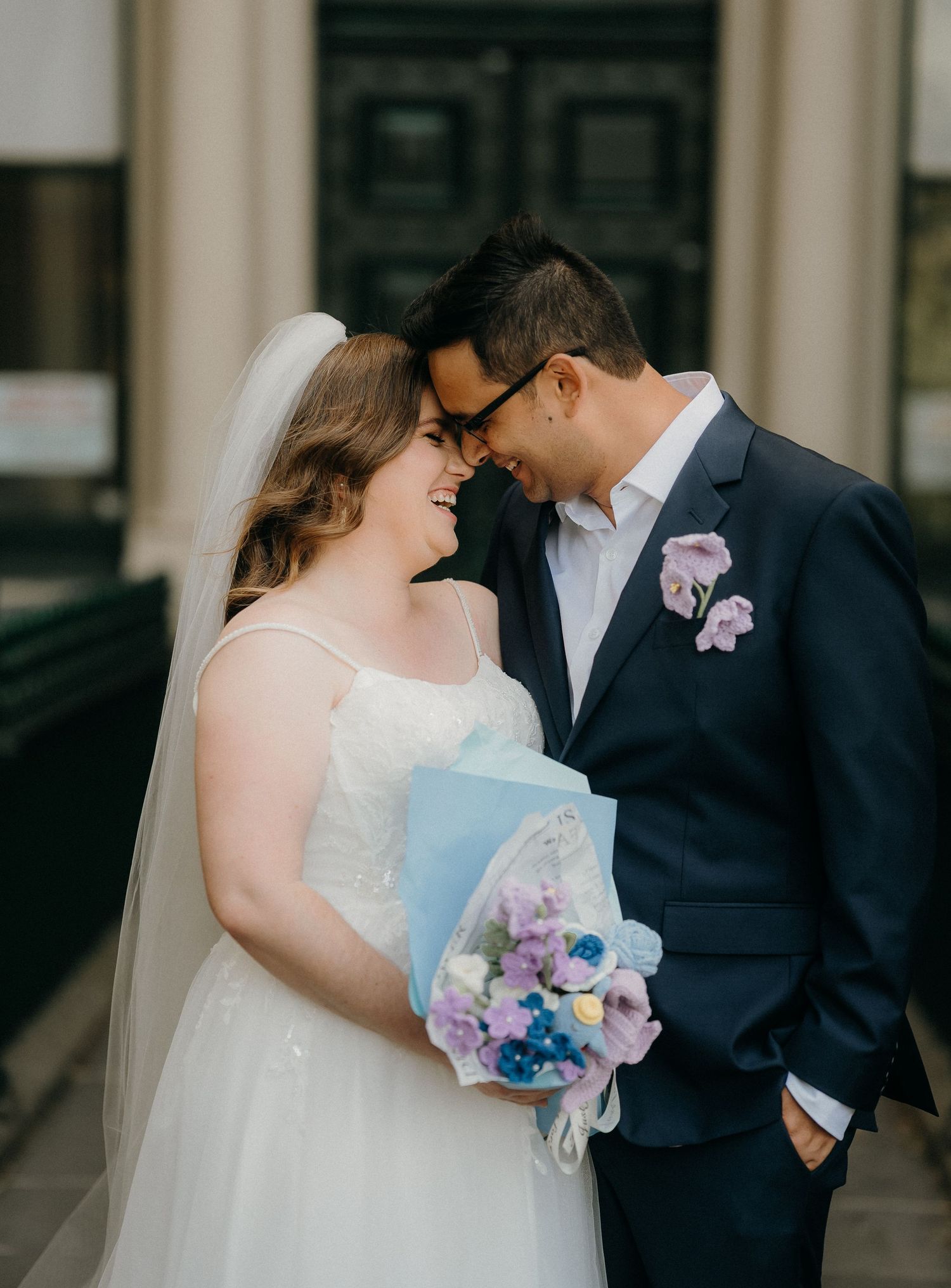 A series of intimate wedding moments captured against a backdrop of classical architecture with purple and blue bouquet.