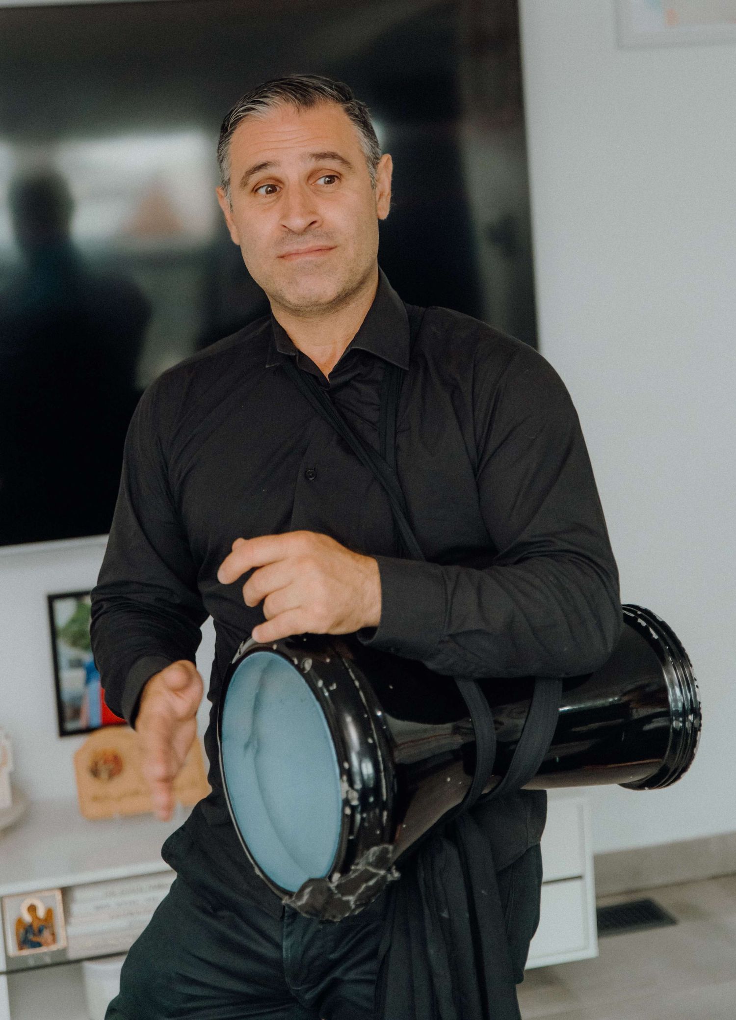 A sequence of four shots showing someone in a black shirt demonstrating different angles of holding a camera lens.