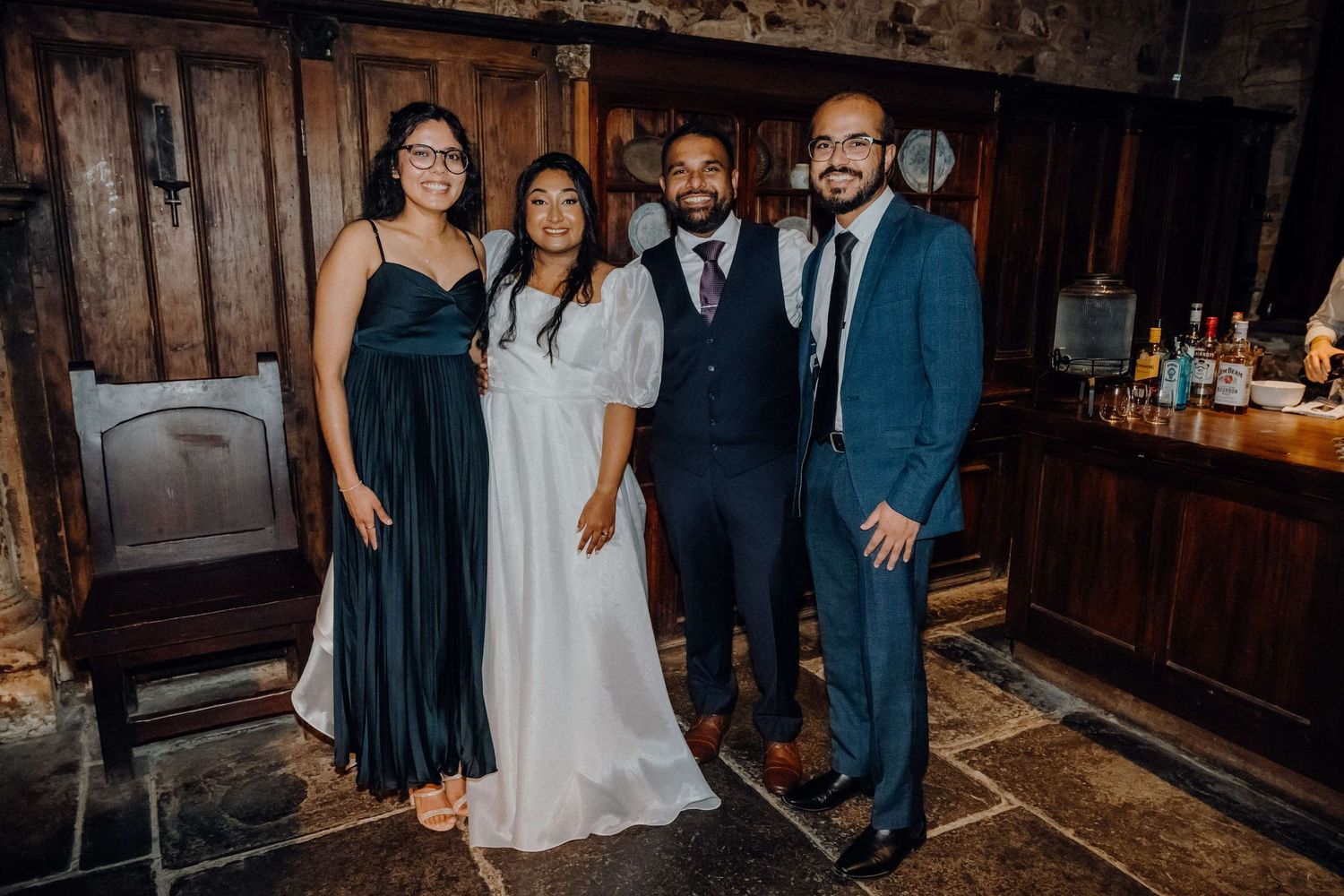 Joyful celebration at a rustic wedding venue with guests dancing and socializing under warm lighting.