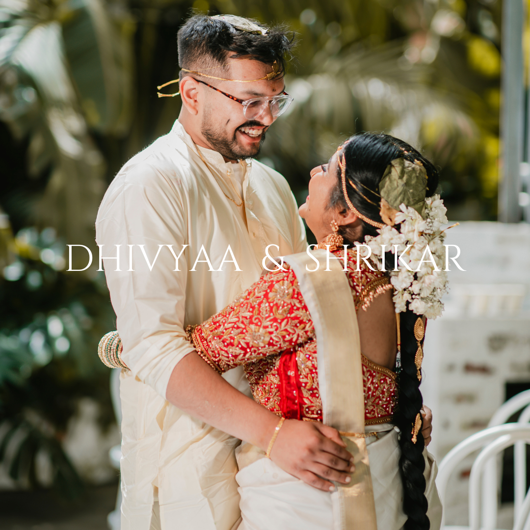 Couple embracing in traditional wedding attire with tropical palm trees in background.