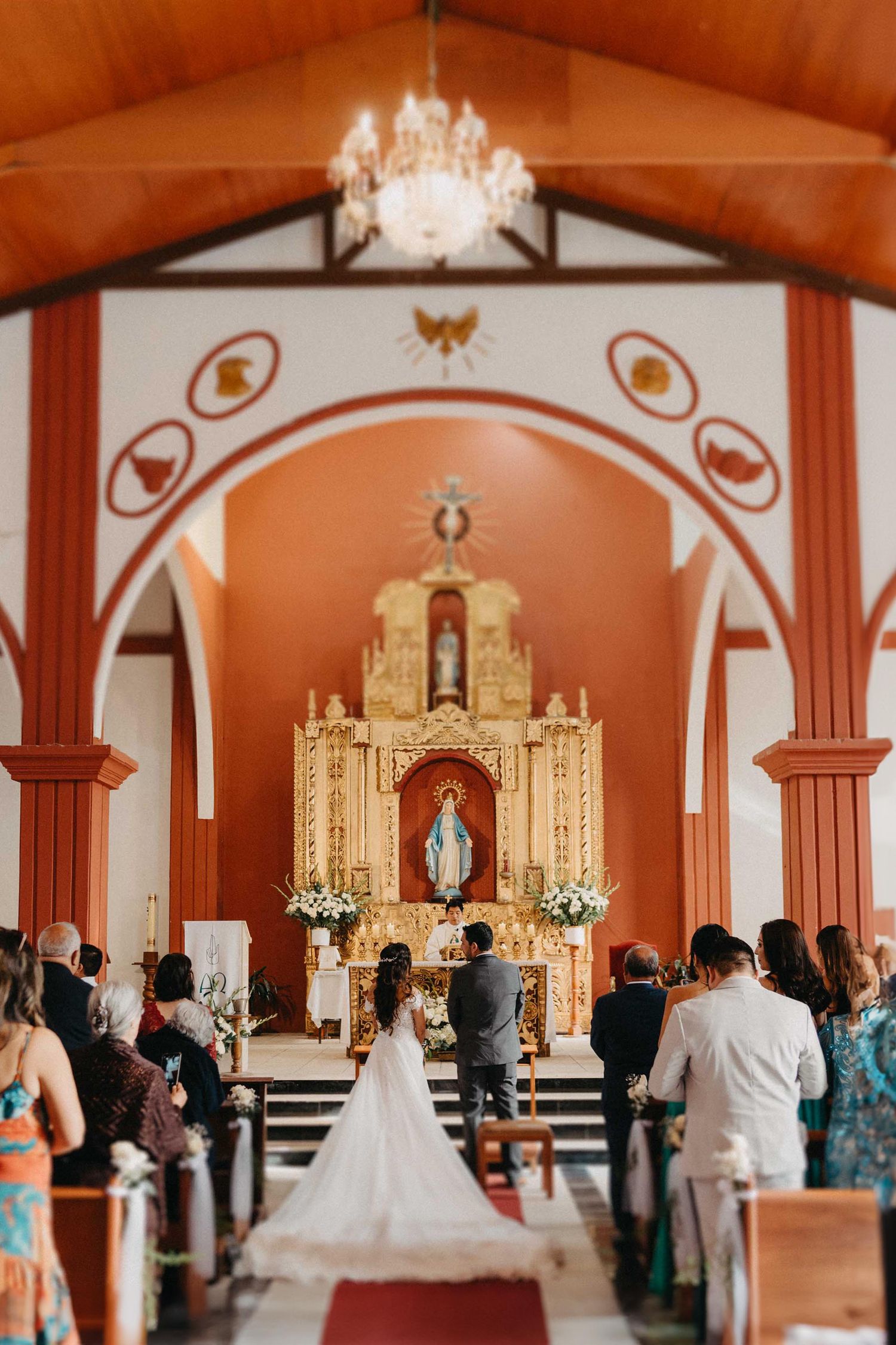 Church wedding ceremony in ornate cathedral with vaulted ceilings and decorative altar.