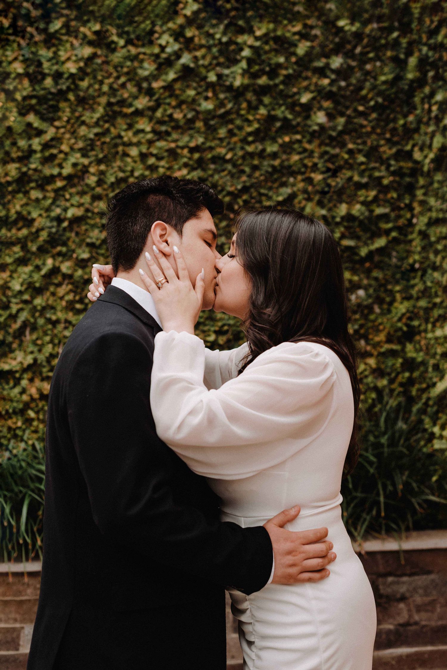 Romantic portrait sequence of a couple embracing and kissing against a leafy garden backdrop.