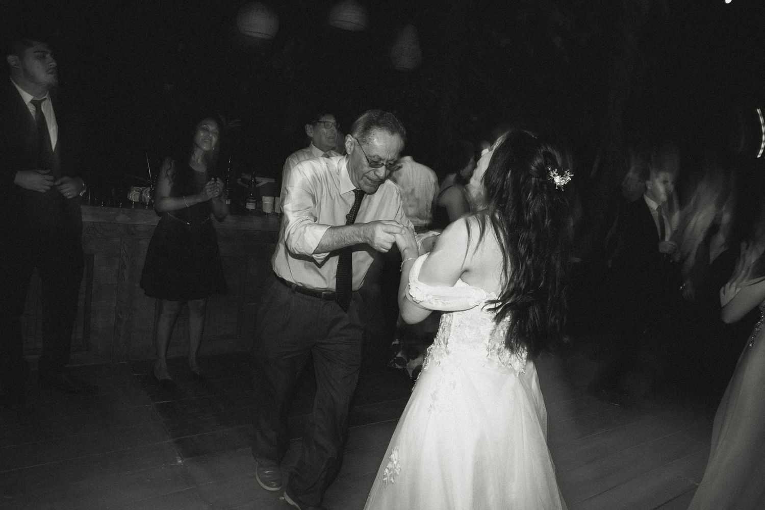 Black and white photo of couples dancing at an evening wedding reception.