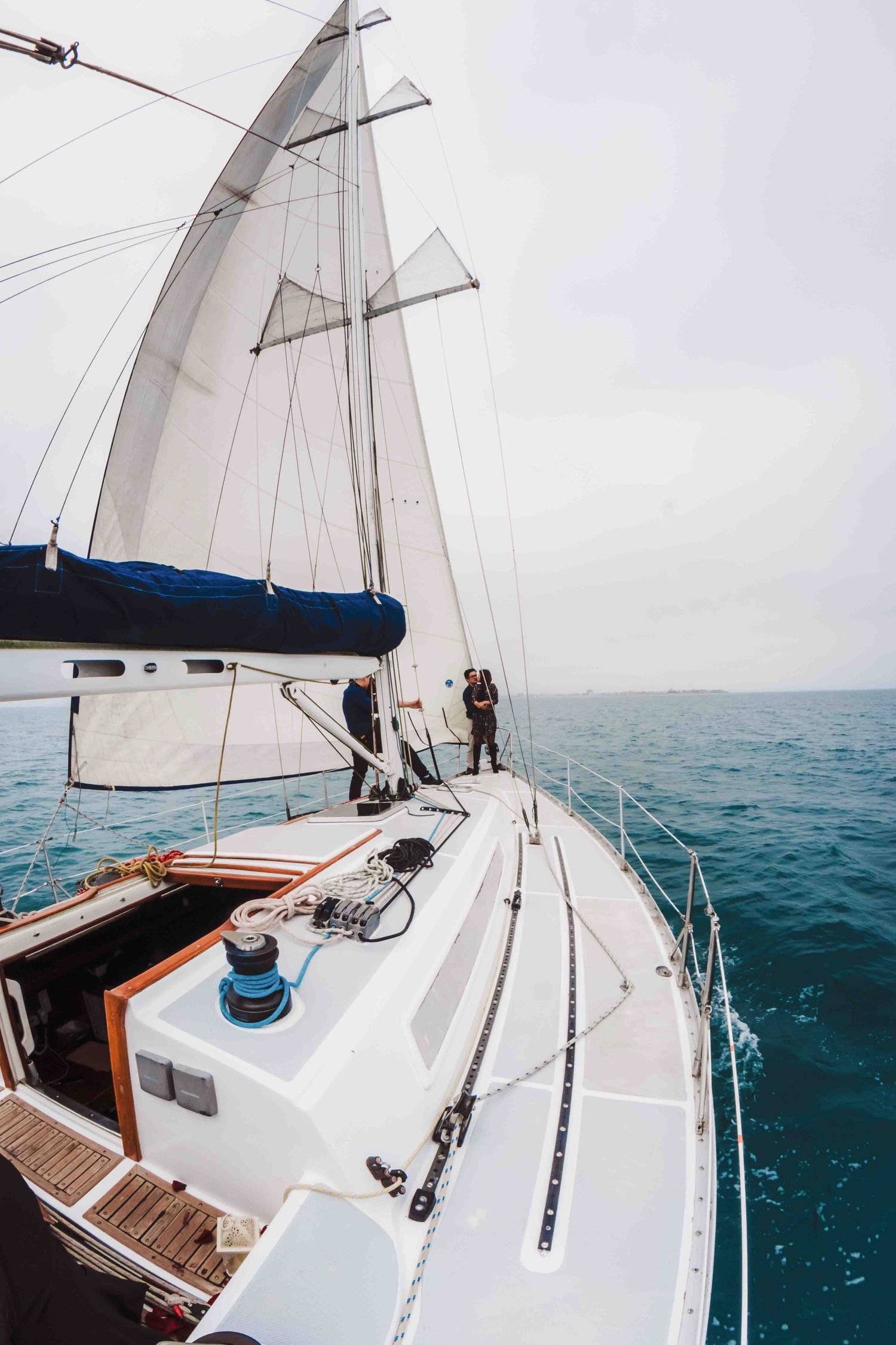 White sailboat glides across blue waters during romantic sailing adventure.