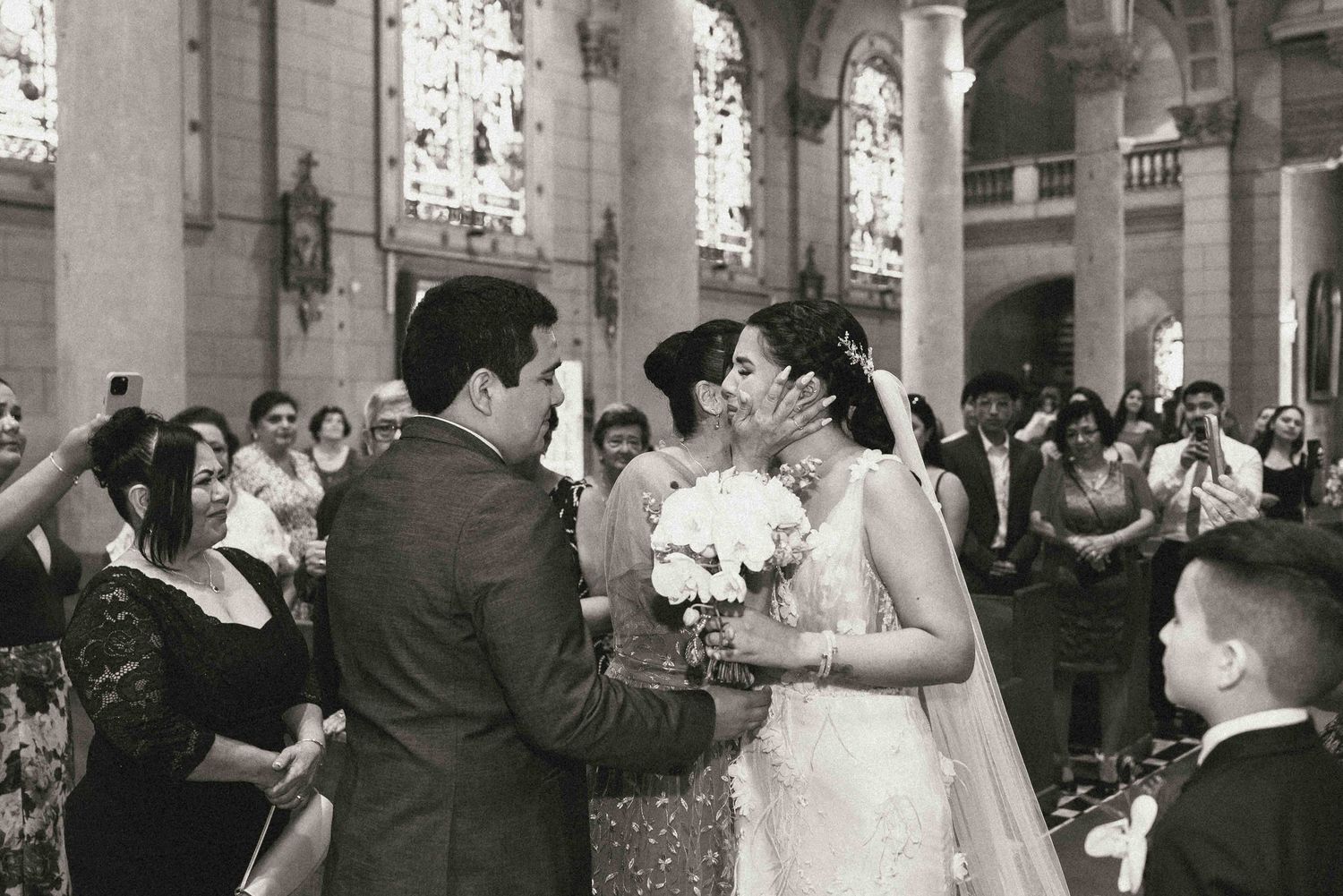 A couple exchanges vows during their traditional church wedding ceremony surrounded by guests in the pews.