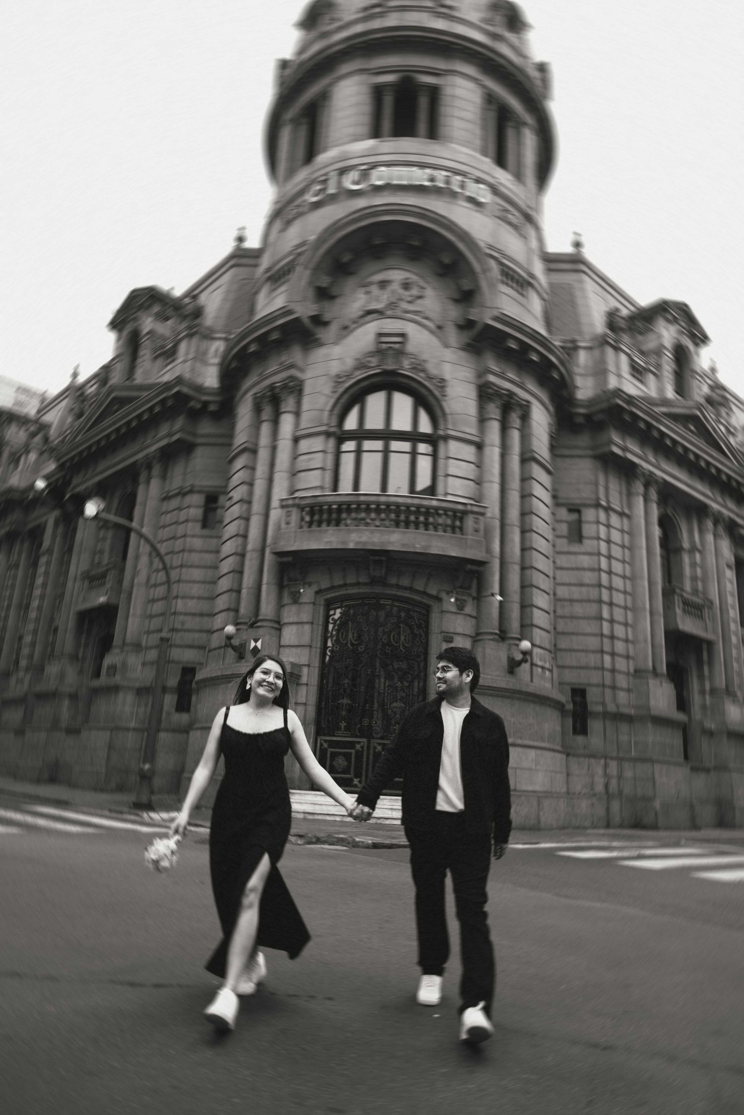 Artistic black and white engagement photos captured in front of a grand historical building.
