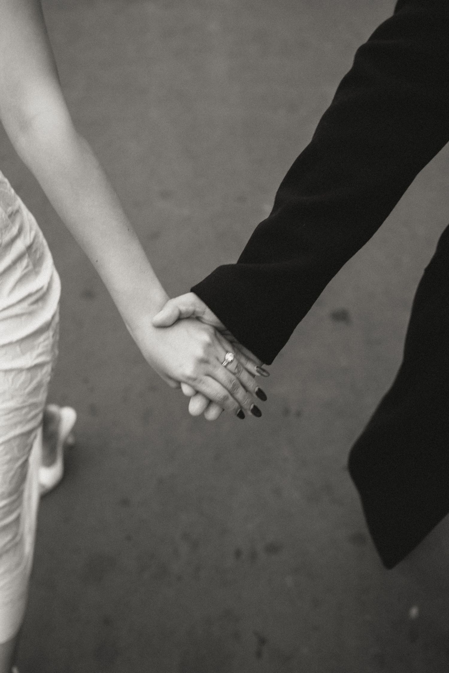 Close-up of hands reaching towards each other in an artistic black and white composition.