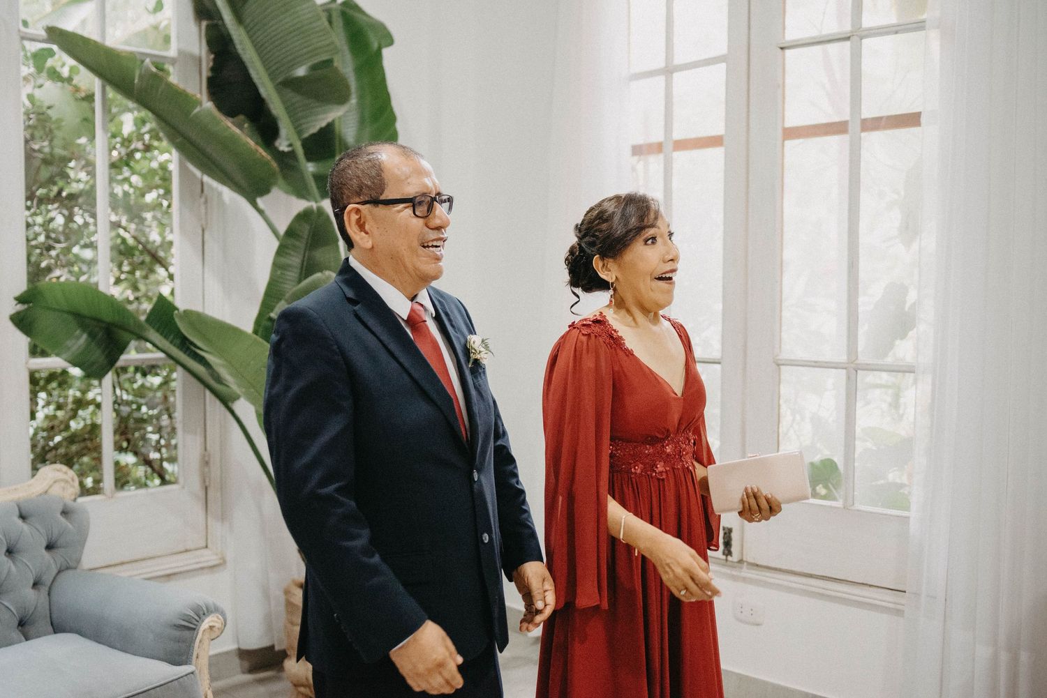 Elegant indoor wedding ceremony setting with warm natural light streaming through large windows.