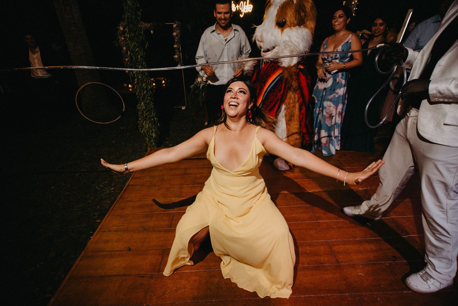 Wedding guests dancing on a wooden dance floor during an evening celebration.