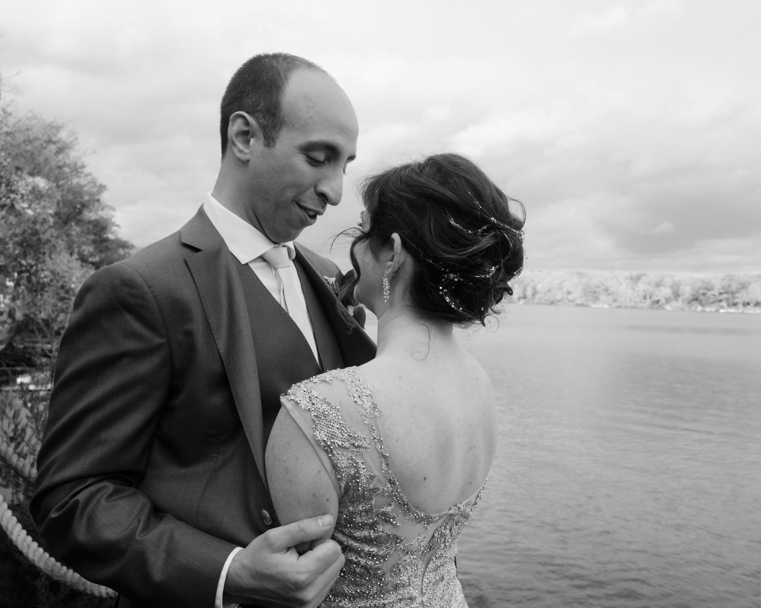Romantic black and white portrait by the water on overcast day.