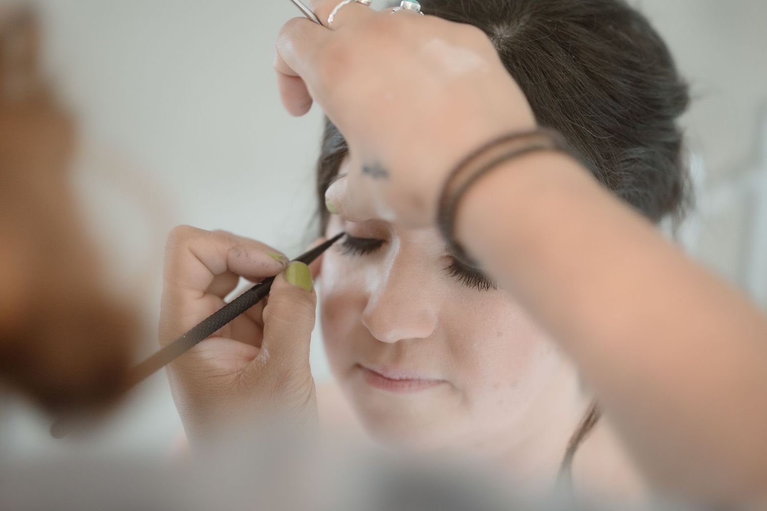 Close-up shot of professional makeup application during wedding preparations.