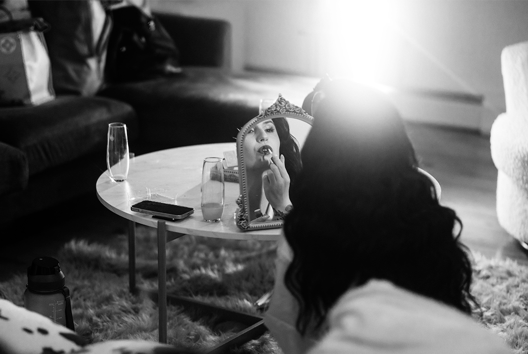 Moody black and white photo of a relaxed scene with champagne glass on a coffee table.