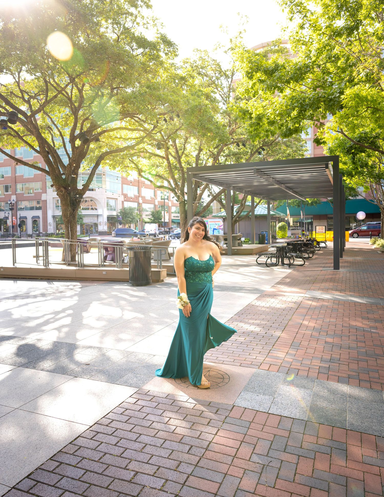 A sequence of photos showing a figure in a teal gown twirling gracefully on a brick plaza with trees in the background.  Pearland Family Pho