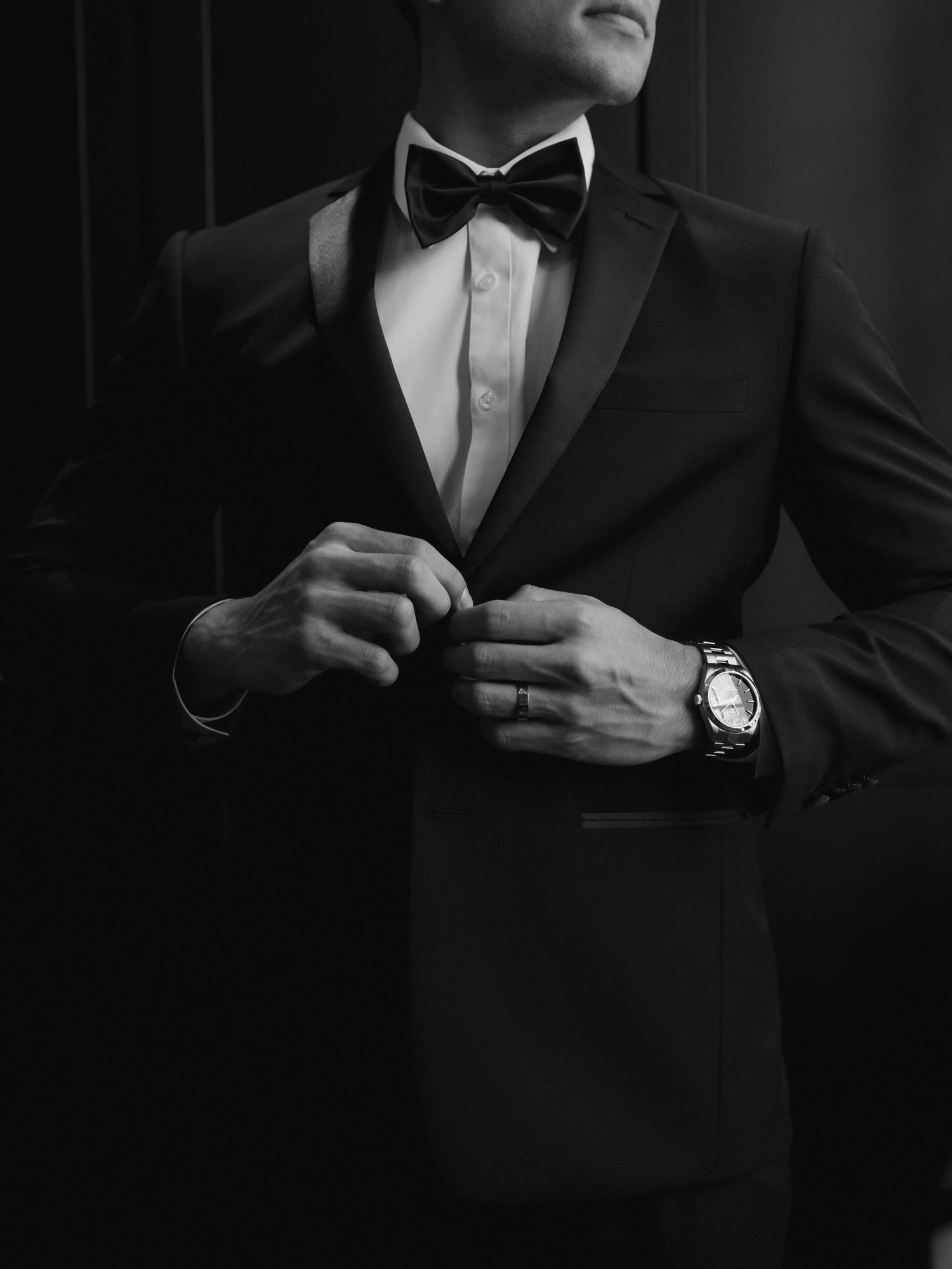 A close-up black and white photo of formal attire showing a black bow tie and white dress shirt collar.