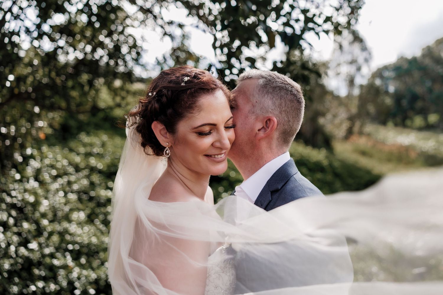 Intimate moment between newlyweds captured in soft natural light.
