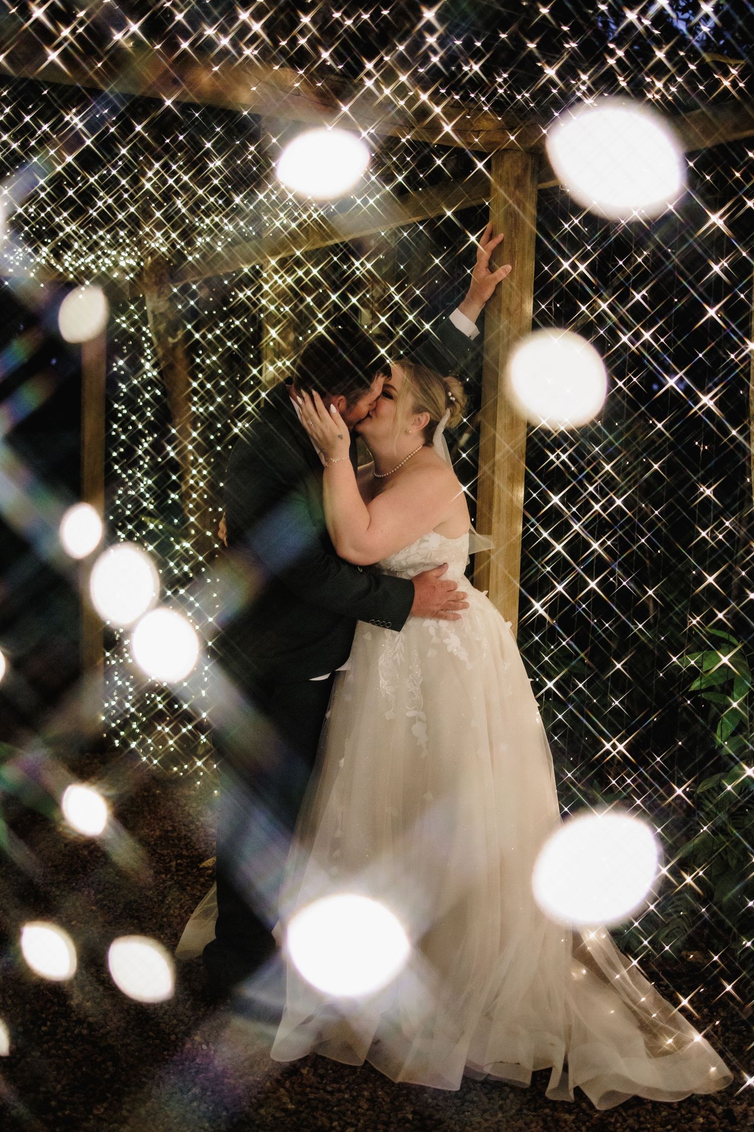 A romantic evening wedding scene with twinkling string lights and bokeh creating a magical, starlit atmosphere.
