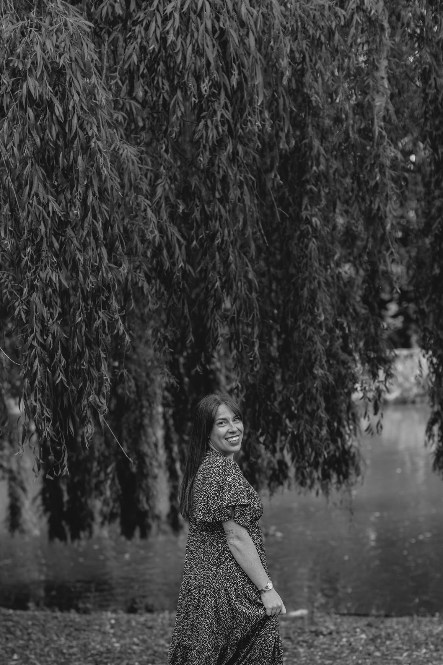 Artistic black and white portrait under a majestic weeping willow tree.