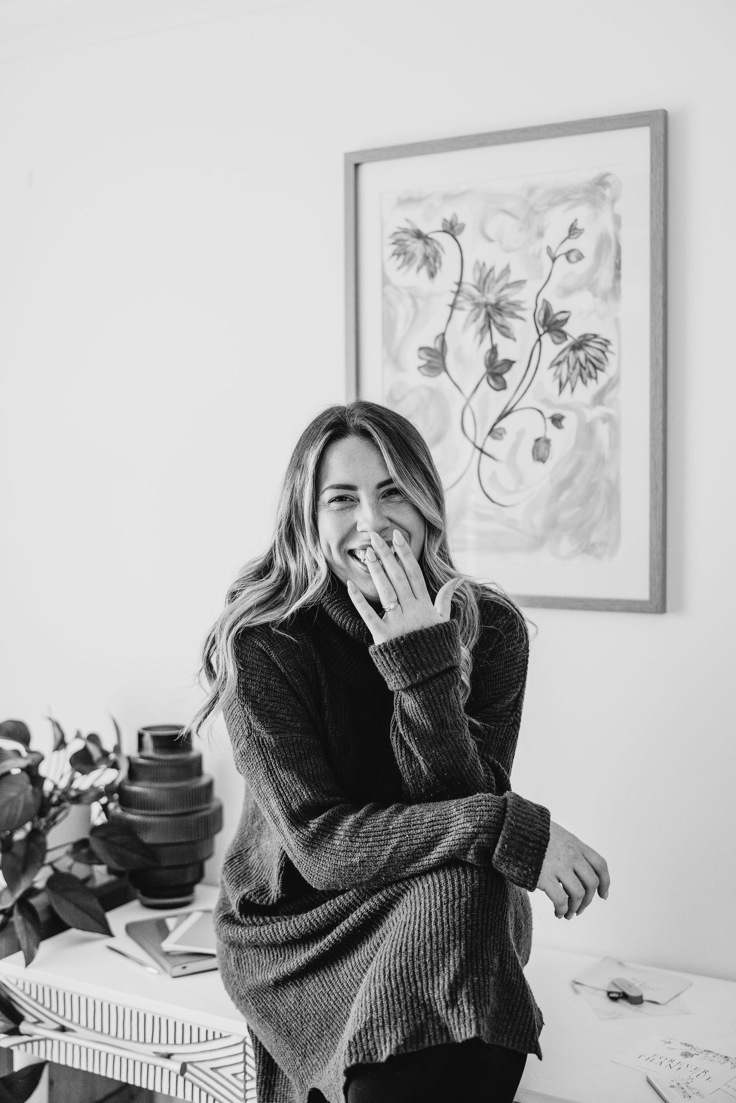 Artistic black and white portraits showing cozy moments with framed artwork in background.