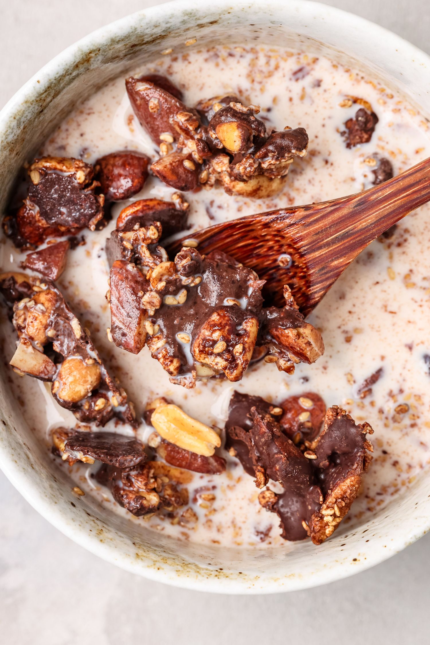 A sequence of five images showing chocolate and caramel candies melting and mixing in a white ceramic dish.