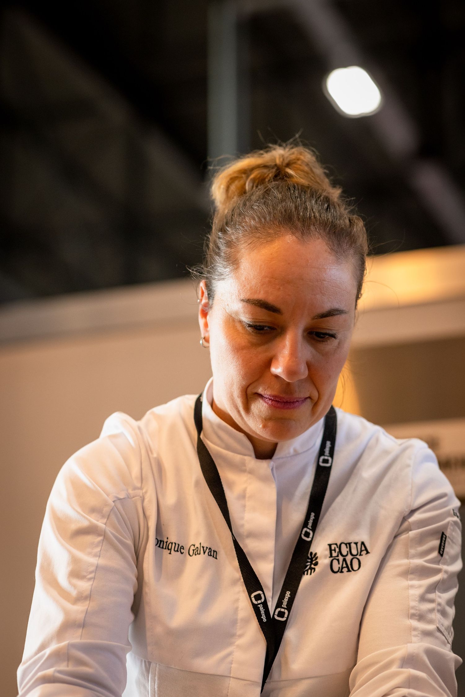 Chef in white uniform working at a culinary station.