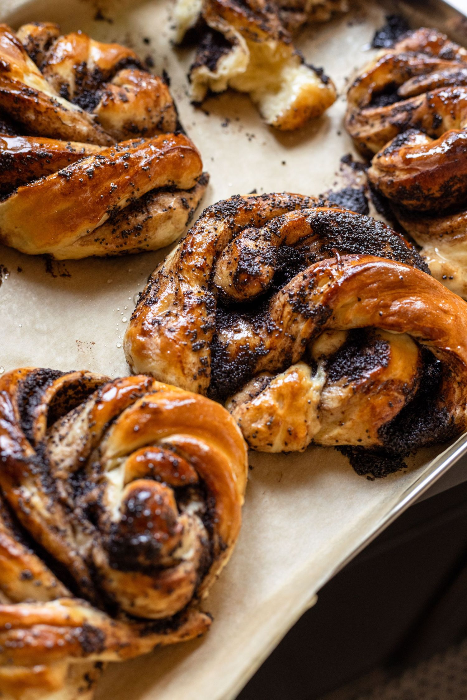 Freshly baked chocolate swirl pastries with a golden brown crust arranged on parchment paper.