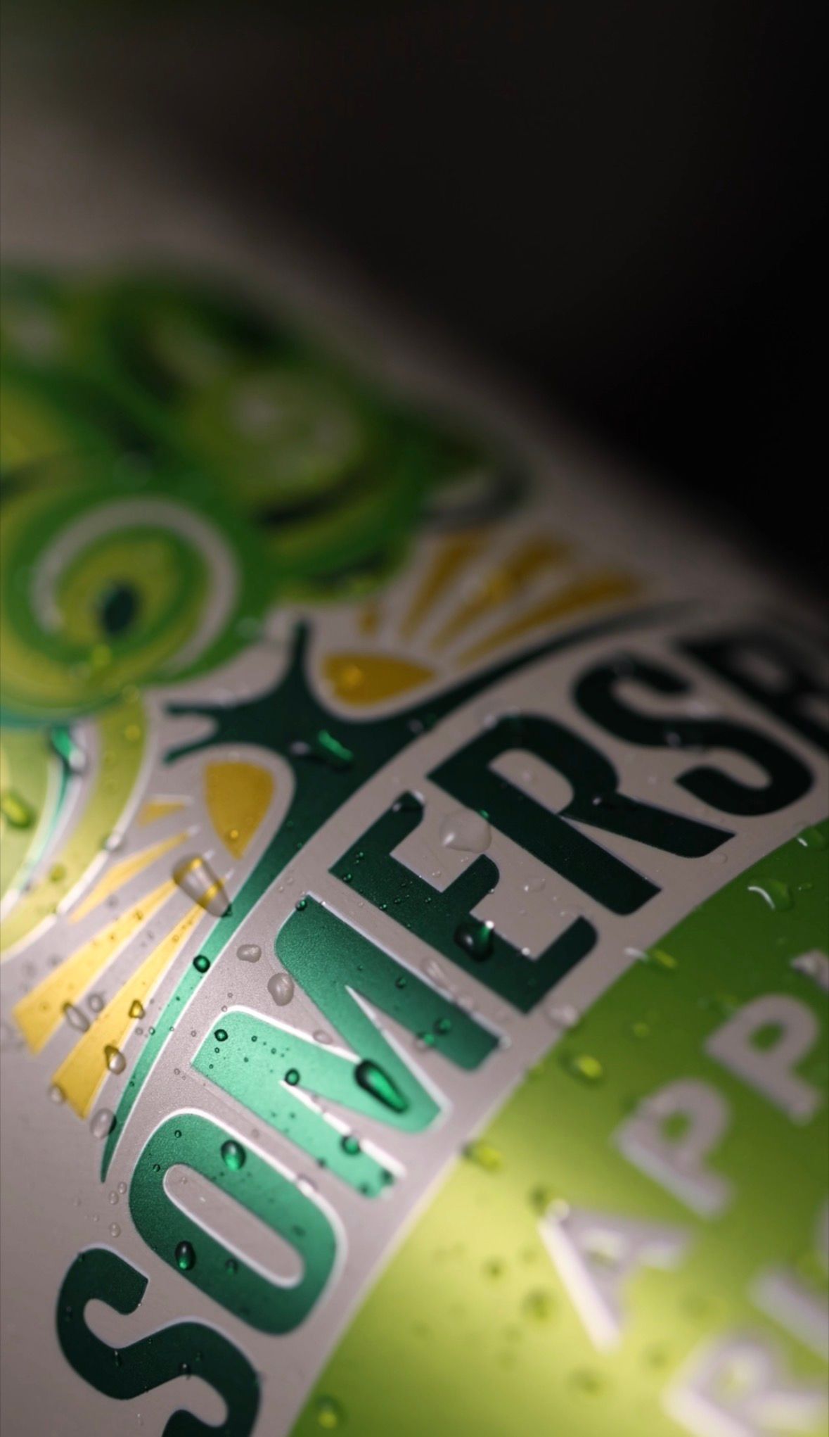 Close-up macro shot of a green Somerset beverage can showing condensation droplets on its surface.
