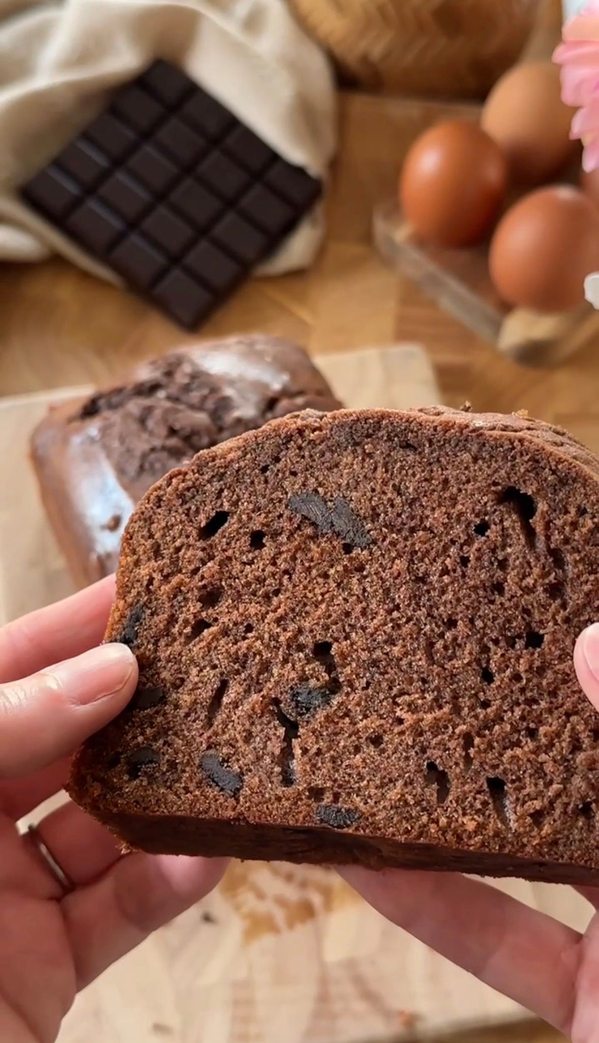 Close-up view of a chocolate cookie or biscotti being broken apart to show its rich, dense texture.