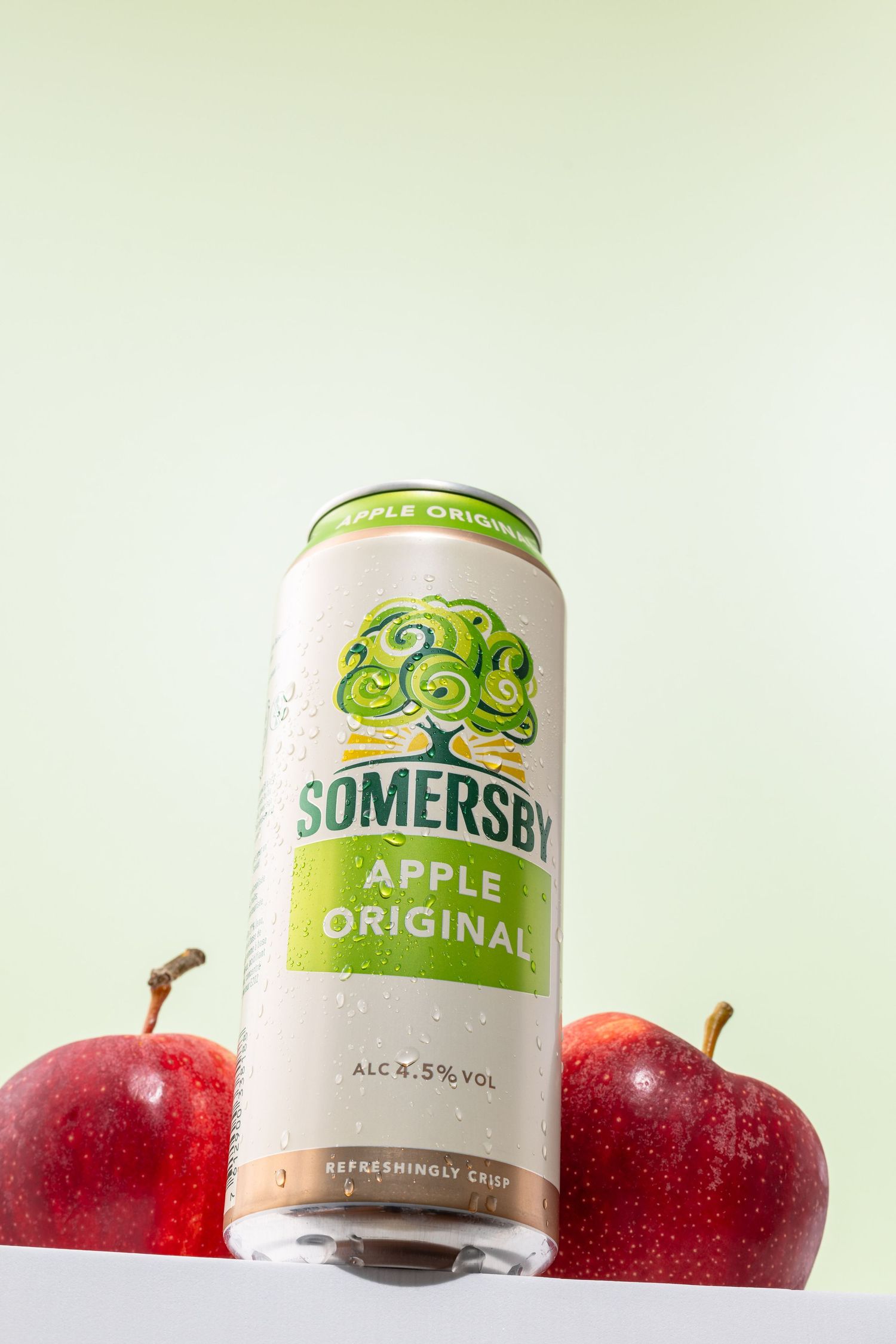 Somersby apple cider cans displayed with fresh red apples in a minimalist product photography setup.