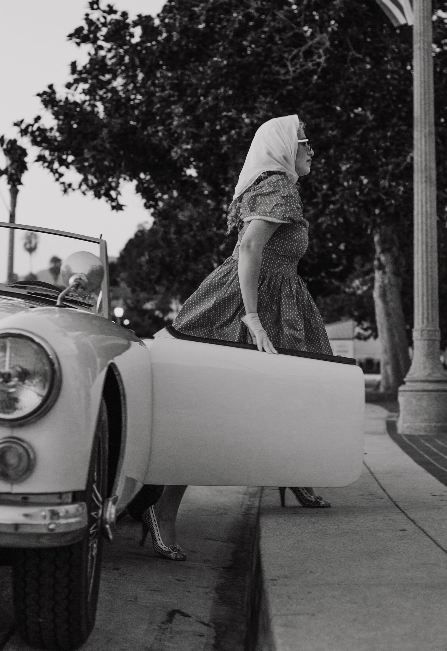 Vintage black and white sequence showing a classic MG sports car from different angles.