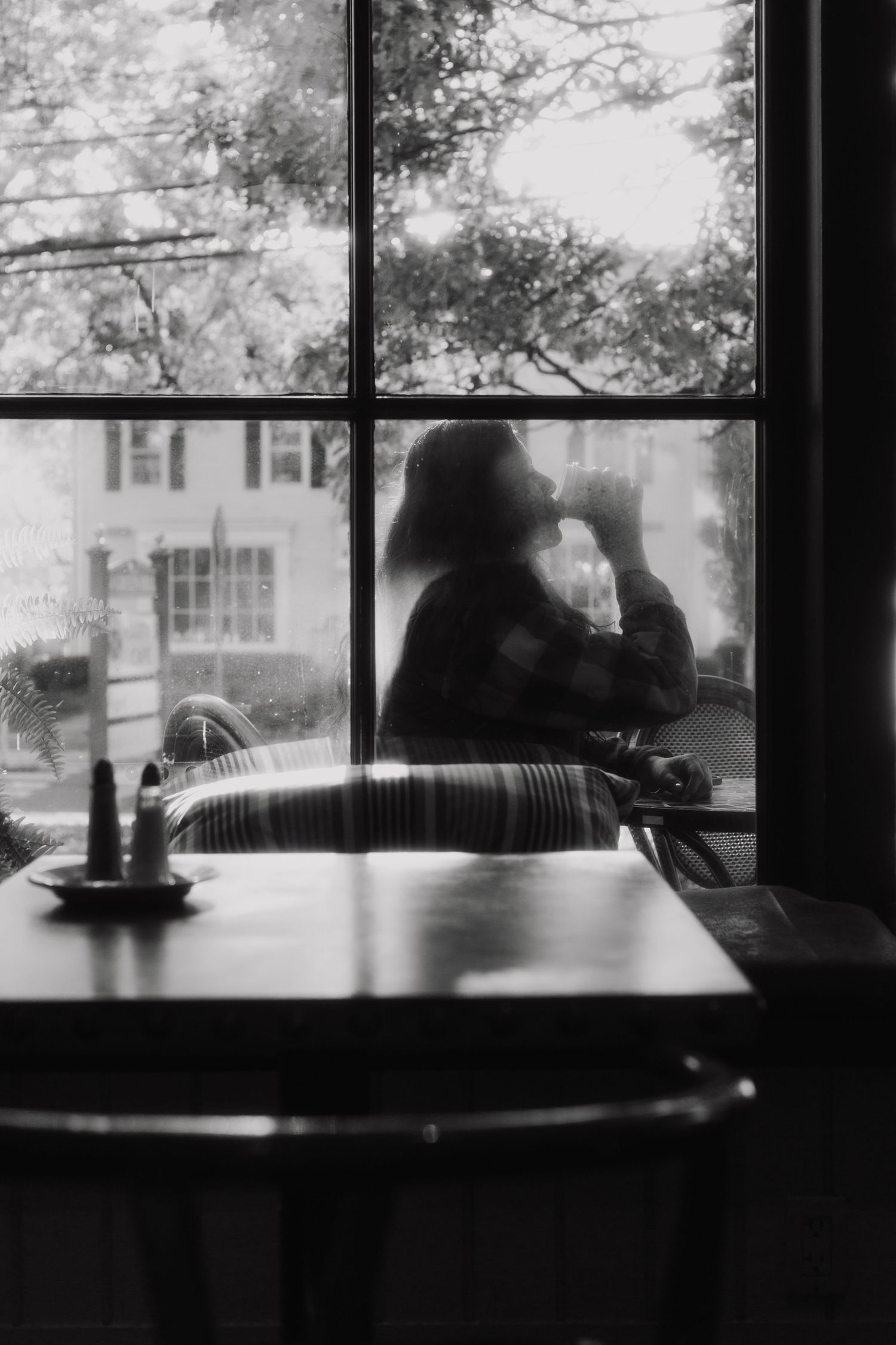 Silhouettes against window light in a cafe or restaurant setting.
