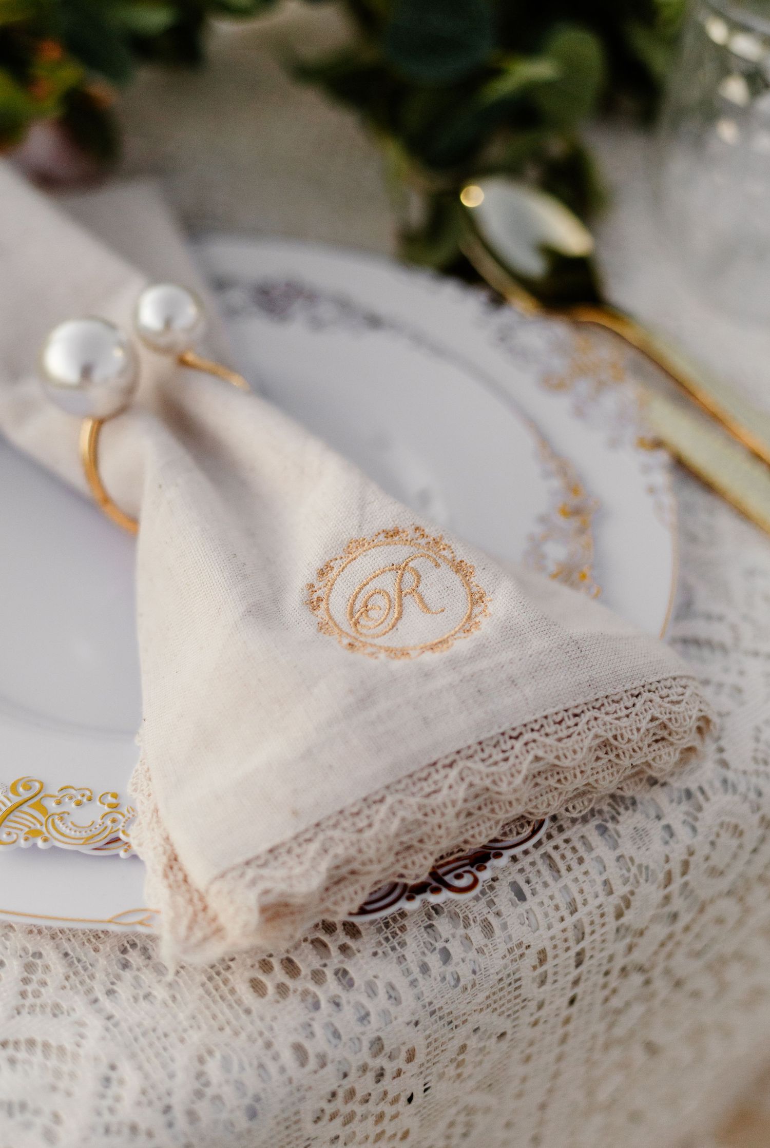 Delicate white lace handkerchiefs with monogrammed embroidery arranged in a row on a light surface.