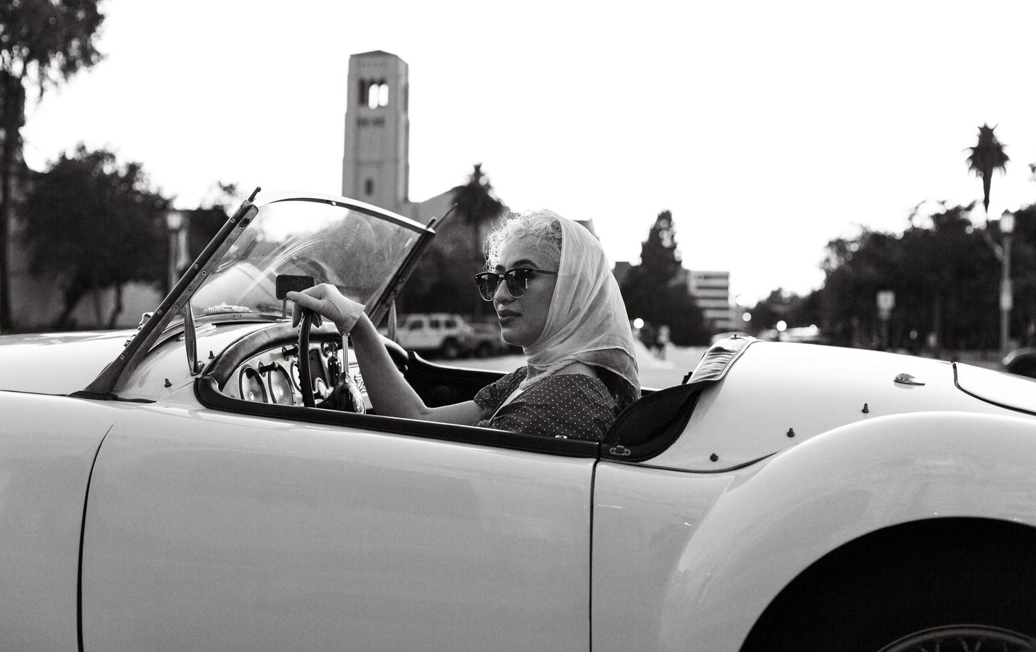 Classic white sports car photographed from the side on a sunny day.