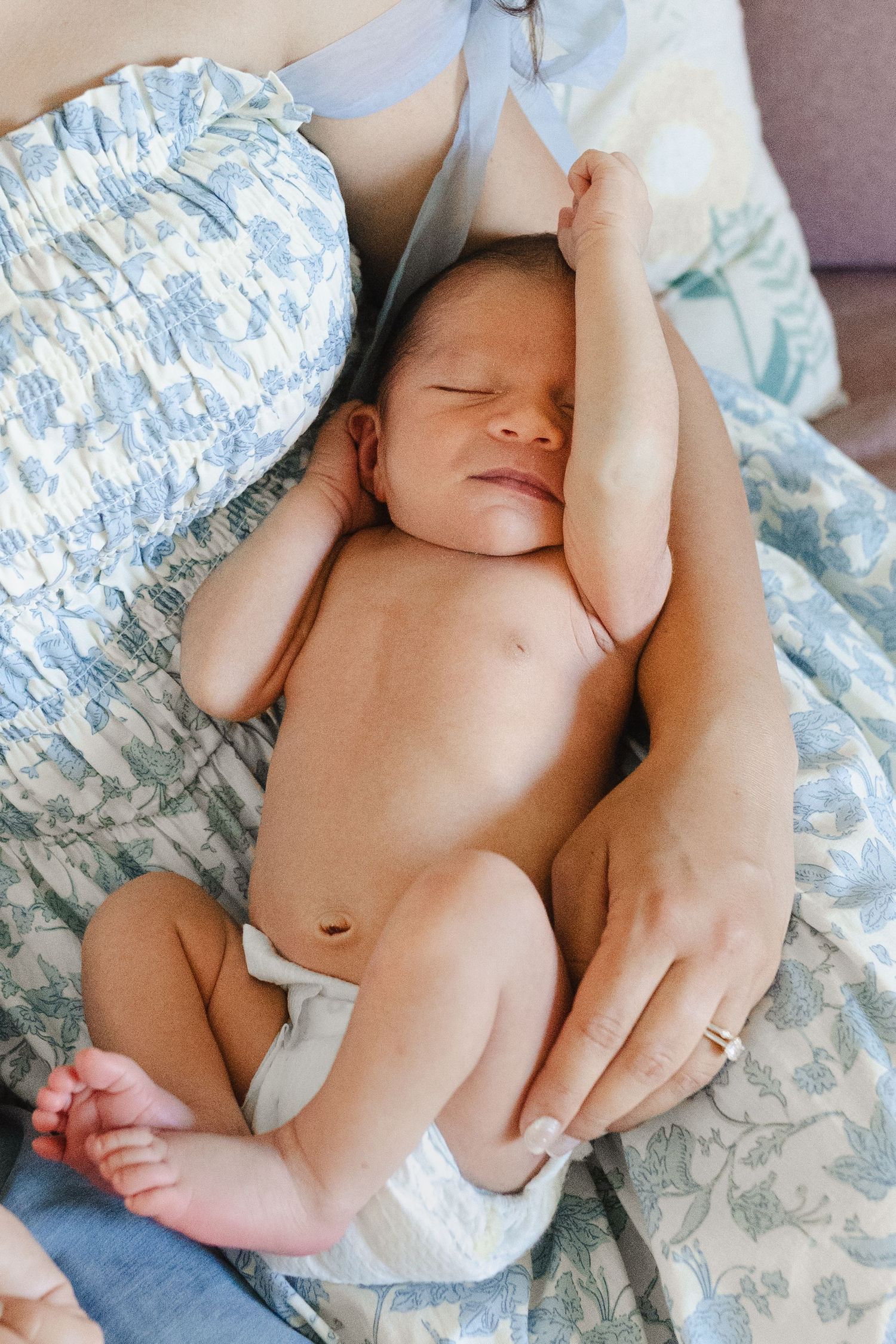 A series of intimate photos showing a sleeping newborn baby wrapped in soft white fabric on floral bedding.