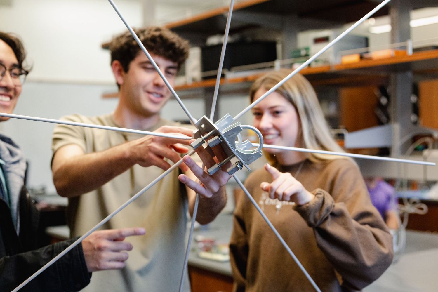 Students in a science lab carefully examine and manipulate glass test tubes during an experiment.