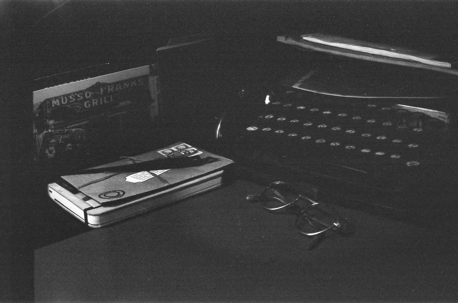 A row of vintage vinyl records in black and white showing their spines lined up on a shelf.