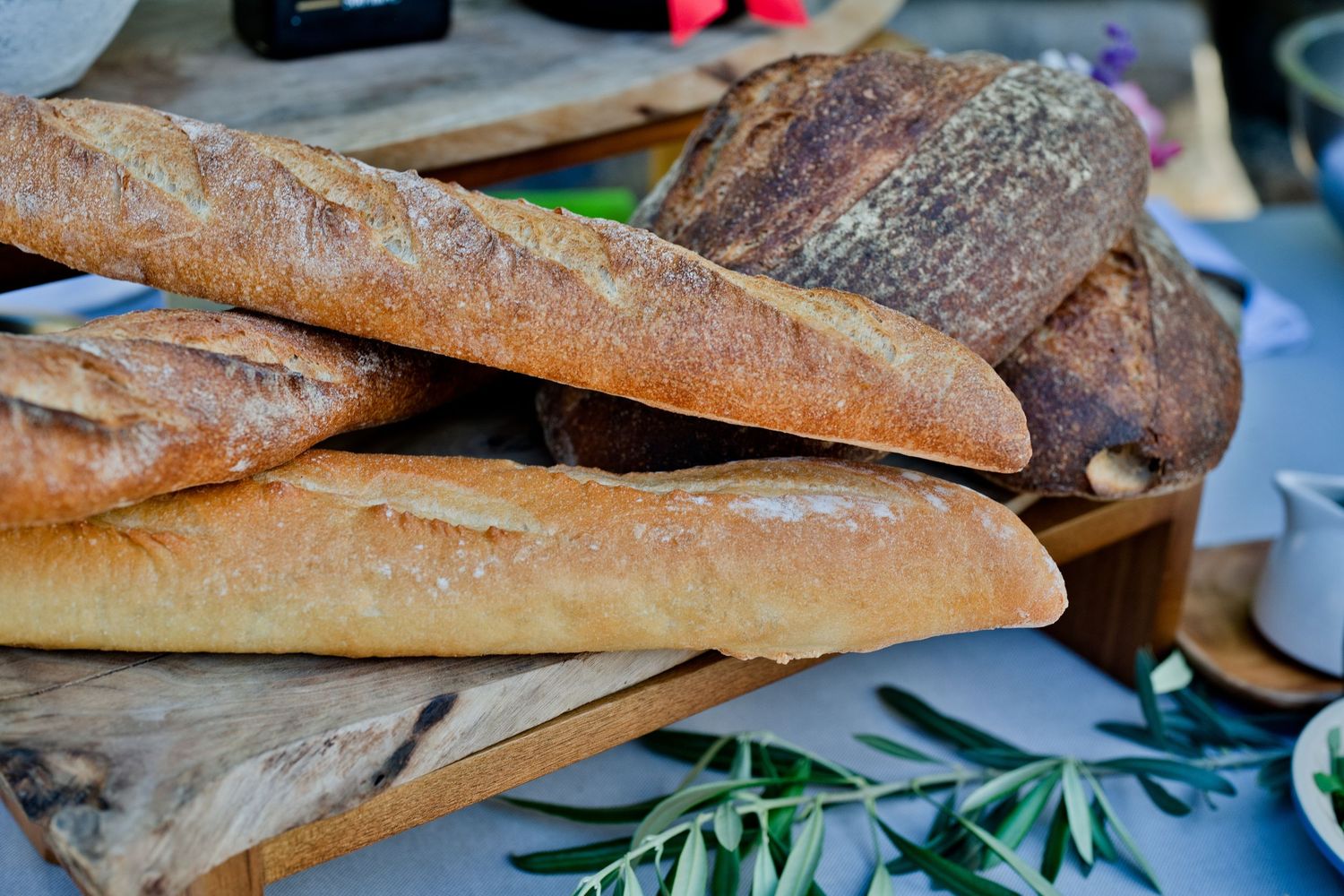 Fresh baked French baguettes and artisanal bread loaves arranged on a wooden surface.
