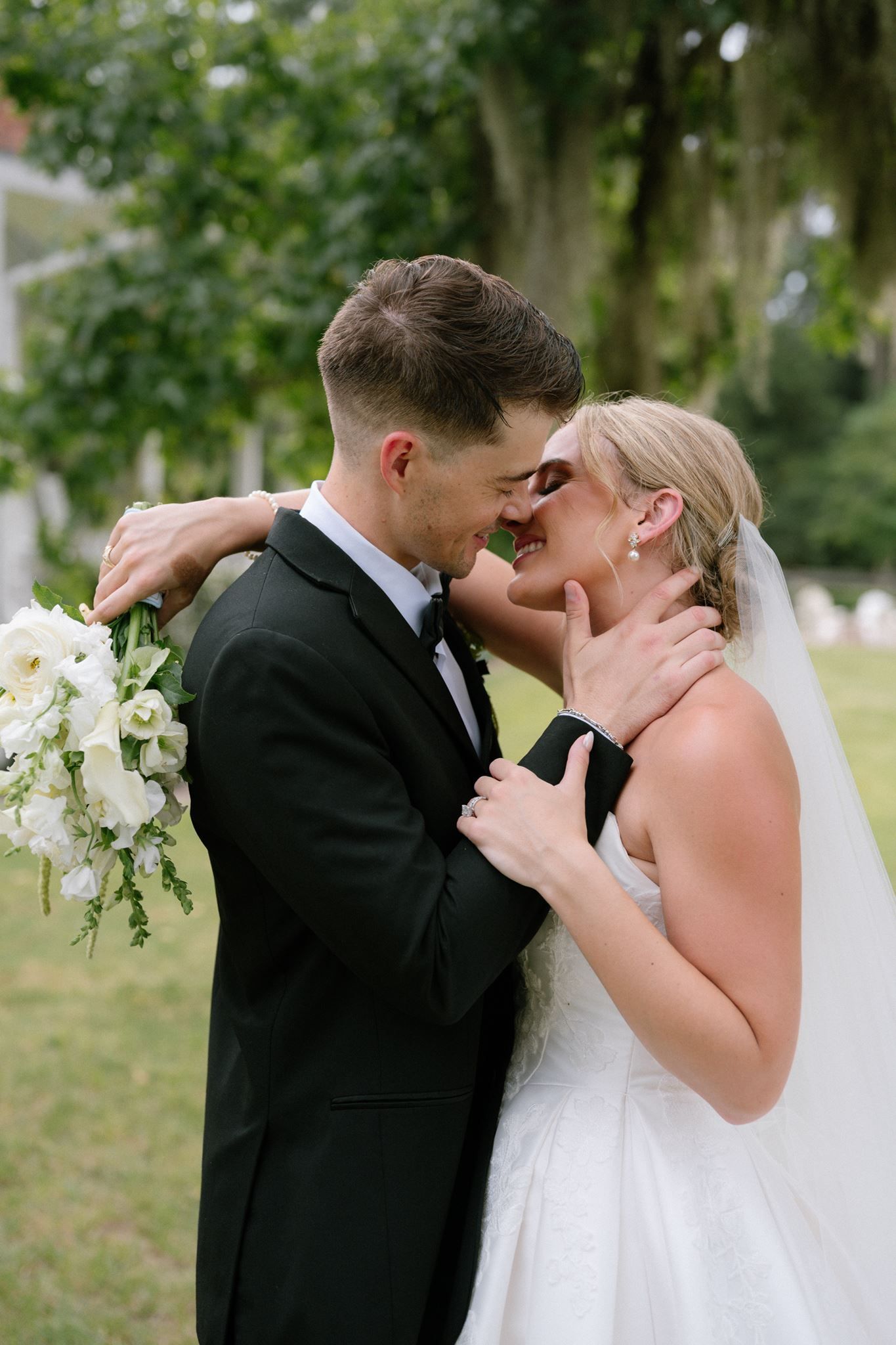 An image of a bride and groom kissing at Historic Hill House, taken by photographer near The Woodlands, Tx.