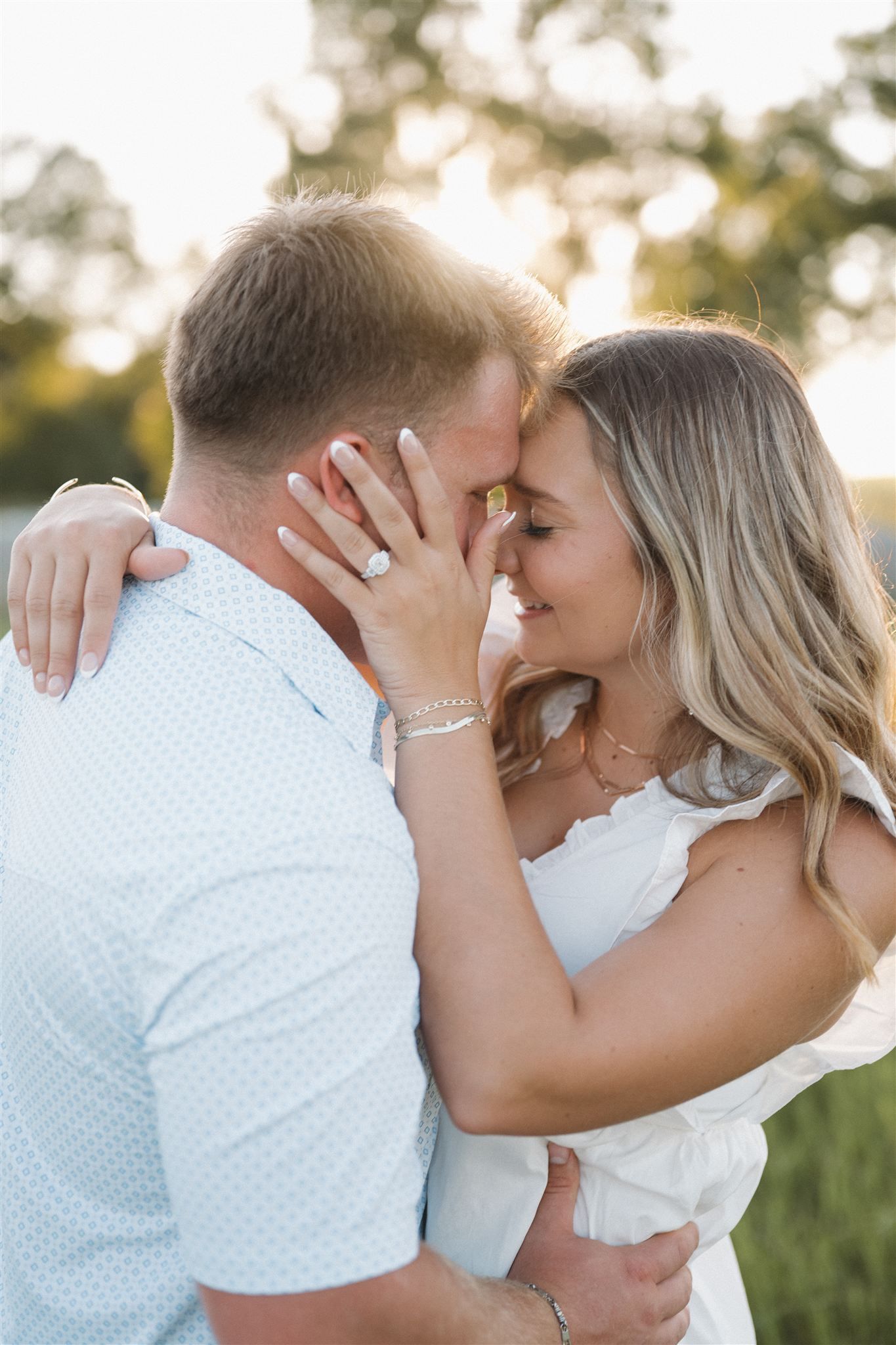 A romantic couple in white outfits share tender kisses in a series of outdoor photos at sunset.