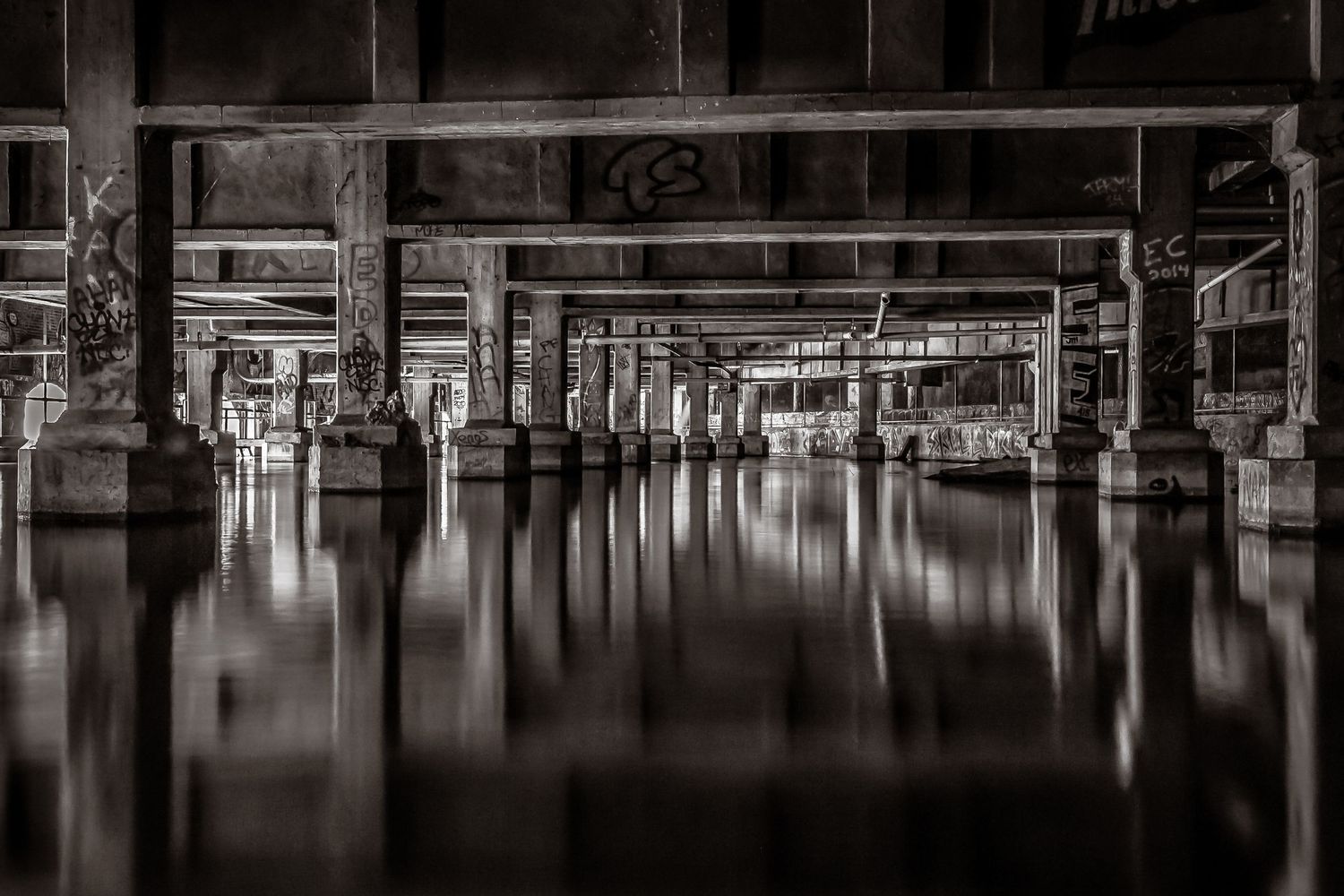 An artsy photo of Aqueducts underneath a city with interesting reflections and graffiti - fine art