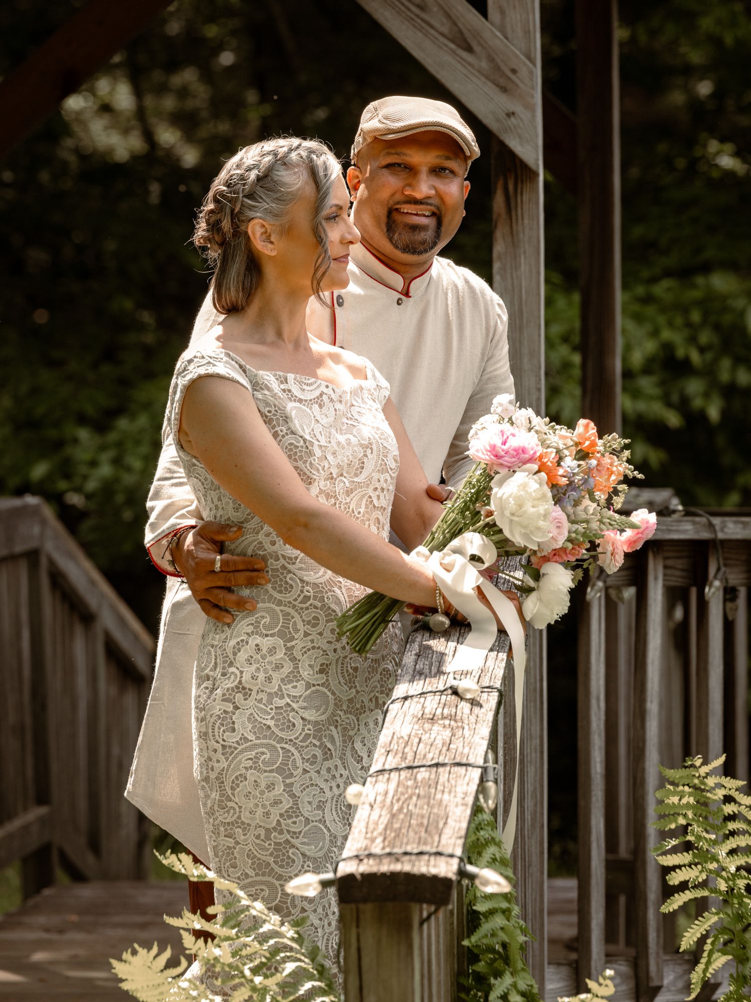 Couple at their elopement posing for a picture on a bridge.