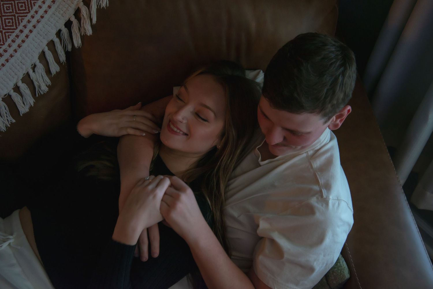 Indoor engagement photo with natural light. Kentucky lifestyle photographer captures candid love and cozy, heartfelt connection.