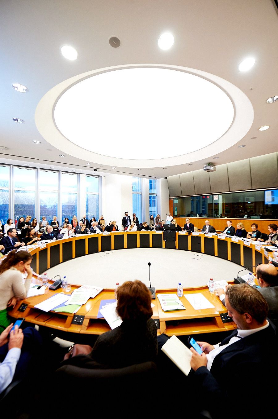 Wide angle view of a modern conference room with curved seating and bright lighting.