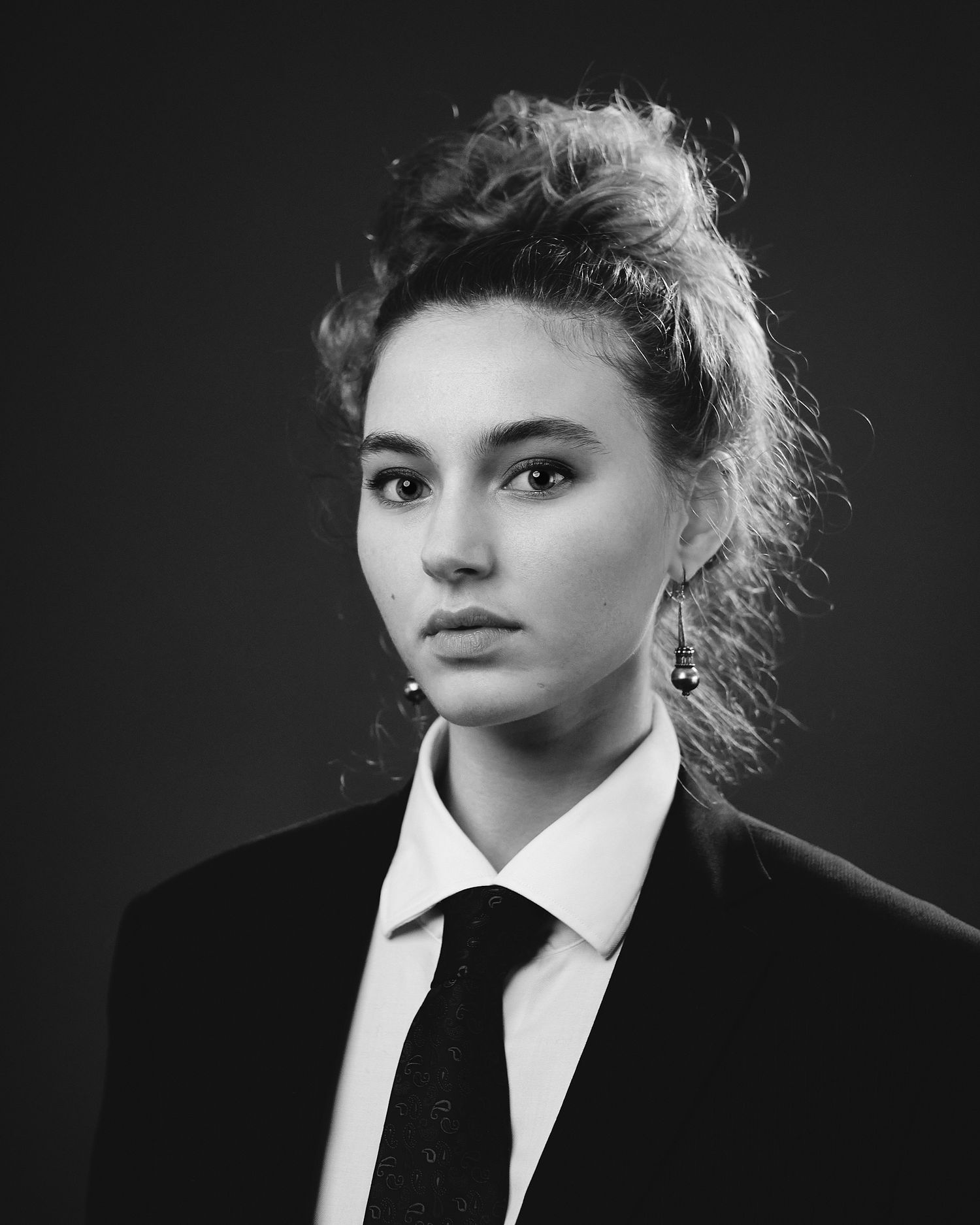 Dramatic black and white portraits in formal attire with white collar and tie.