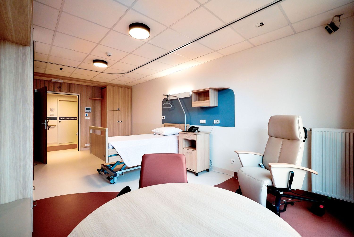 Modern hospital room interior with medical bed and window views.