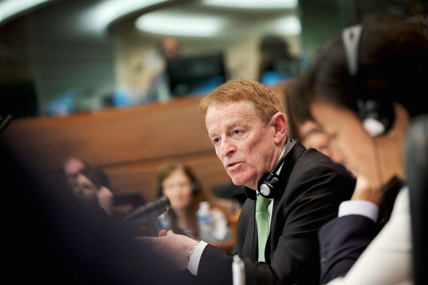 Officials seated at conference table during European Parliament session.