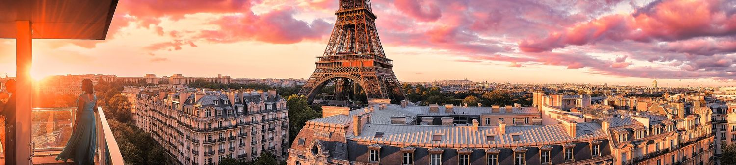 Stunning panoramic sunset view of Paris cityscape with Eiffel Tower and orange sky.