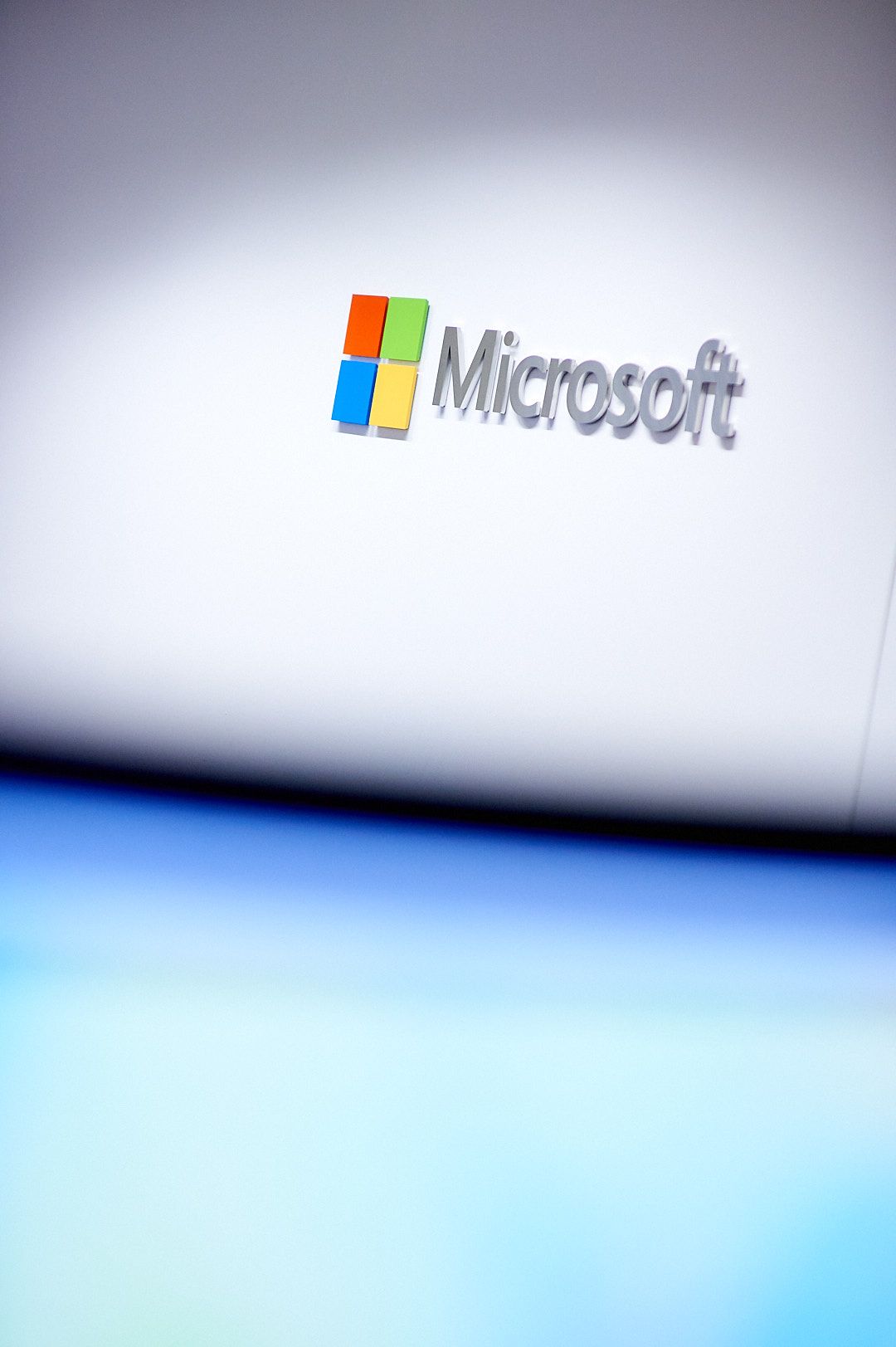 Microsoft logo on gradient blue background with minimalist design.