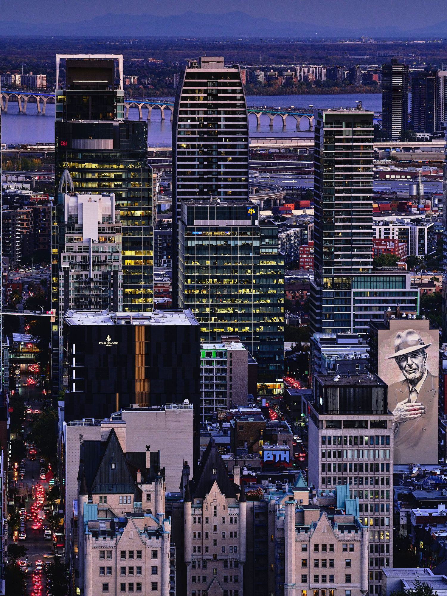 Modern city skyline at dusk with illuminated skyscrapers and office buildings.